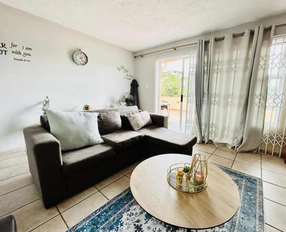 a living room with a couch and a table at Makwande Self-Catering Apartment in Durban