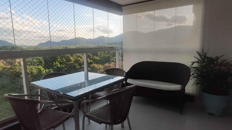een tafel en stoelen in een kamer met een groot raam bij Campo dos Lirios in Curitiba