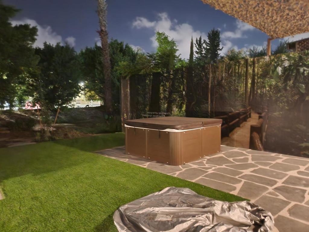 a backyard with a hot tub in the grass at Nono in Qiryat Bialik