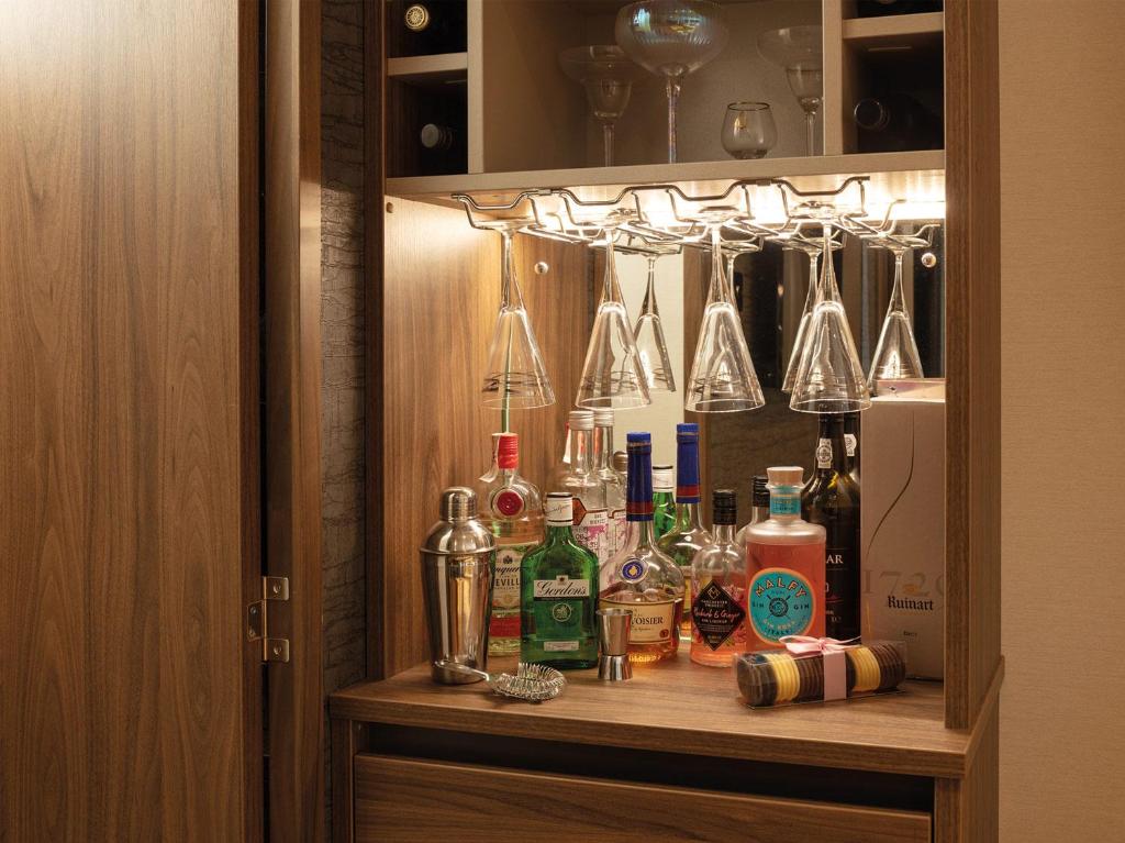 a cabinet with bottles and glasses on a shelf at Beachwood 21 in Camber