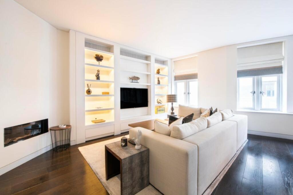 sala de estar con sofá blanco y TV en Prime Mayfair Pied De Terre Sleeps 6 Top Floor en Londres