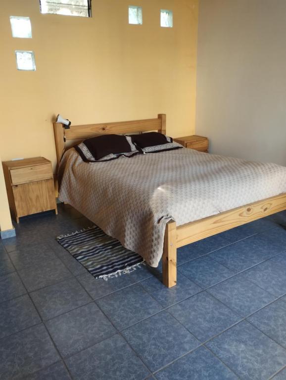 een slaapkamer met een groot bed met een houten frame bij El naranjo in Mendoza