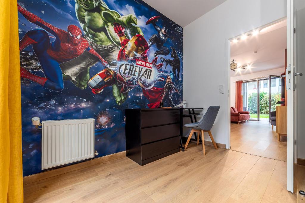 a living room with a superhero mural on the wall at Planète Erevan - 10min from DisneyLand, Free Parking, Self-Checkin in Montévrain