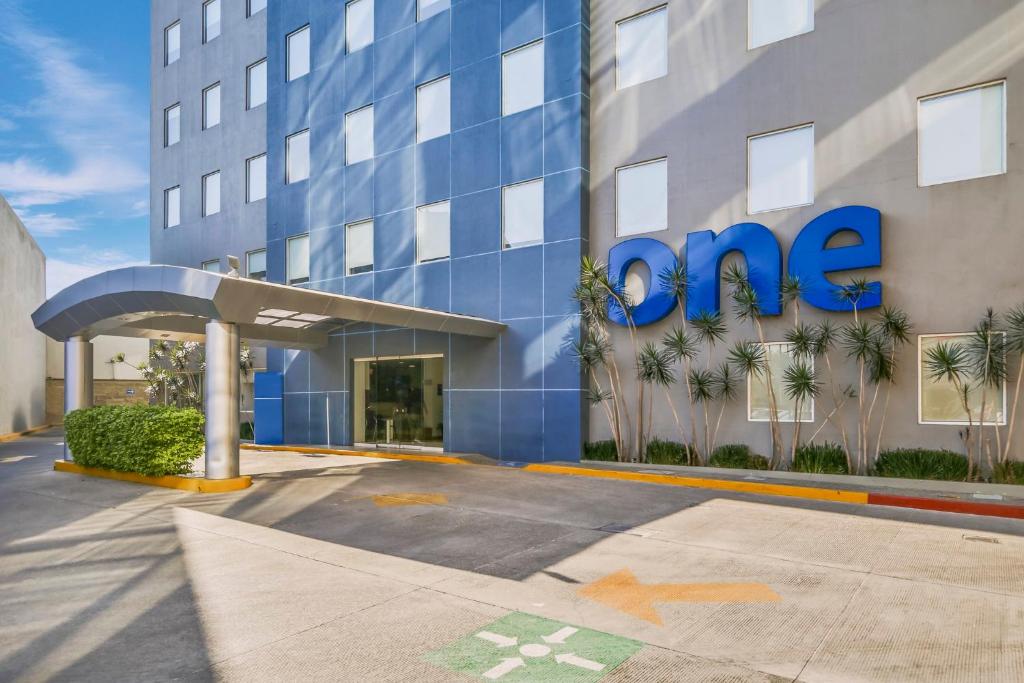 a blue building with the one sign on it at One Leon Poliforum in León