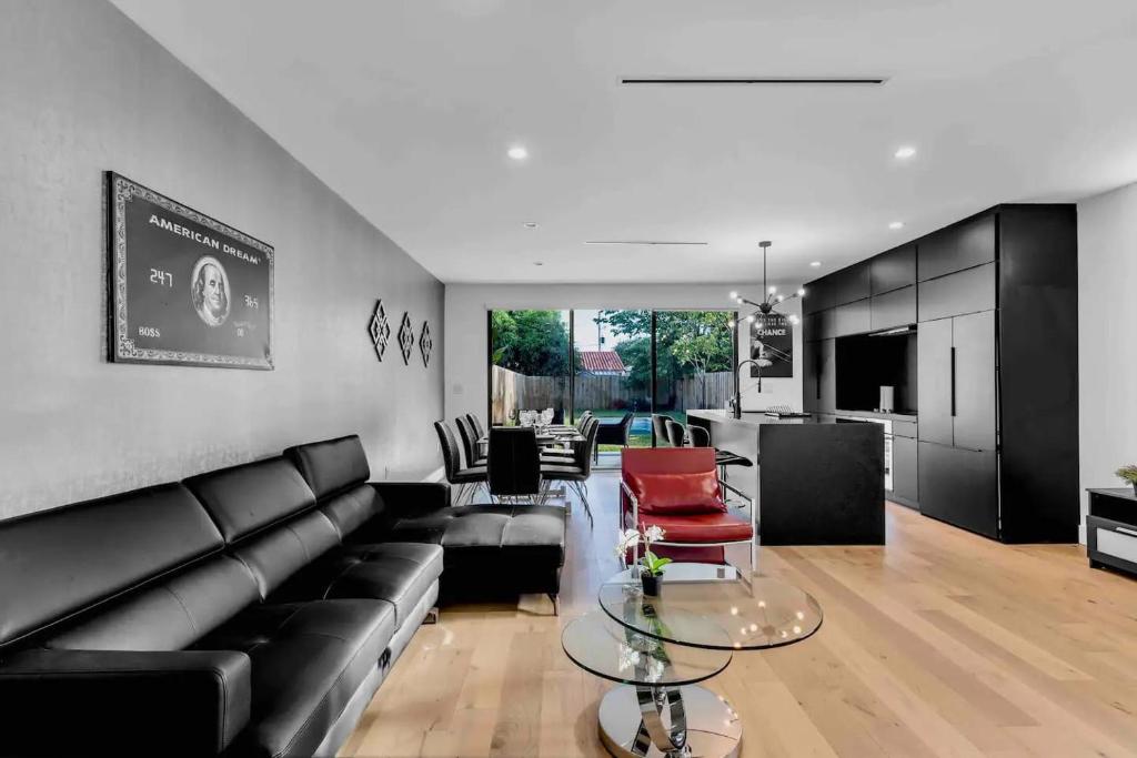 a living room with a black couch and red chairs at Paradise House w Pool & Yard in Miami