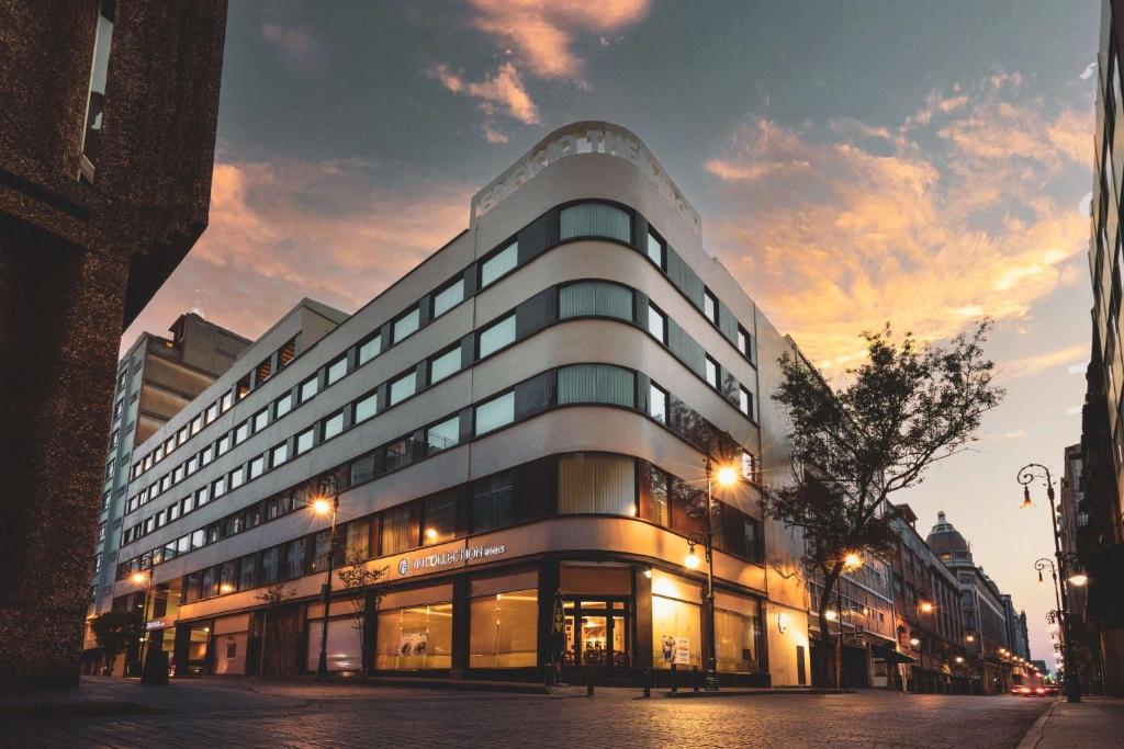 ein Gebäude auf einer Stadtstraße bei Sonnenuntergang in der Unterkunft NH Collection México City Centro Histórico in Mexiko-Stadt