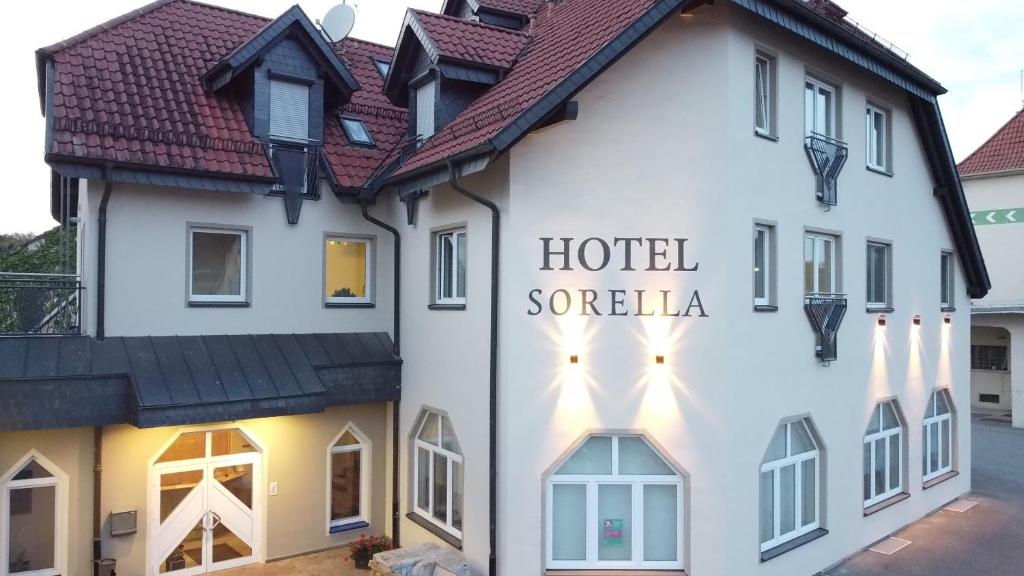 un hôtel avec un panneau sur le côté d'un bâtiment dans l'établissement Hotel Sorella, à Ittlingen