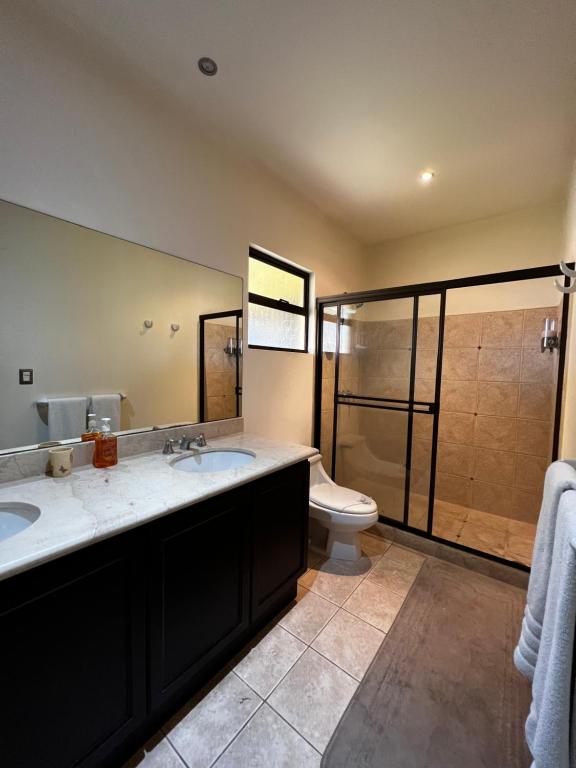 La salle de bains est pourvue de 2 lavabos et d'une douche. dans l'établissement Dream Site near Punta Leona, à Jacó