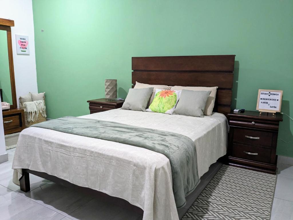 una camera con un grande letto con testiera in legno di Estudio Biznaga a San José del Cabo