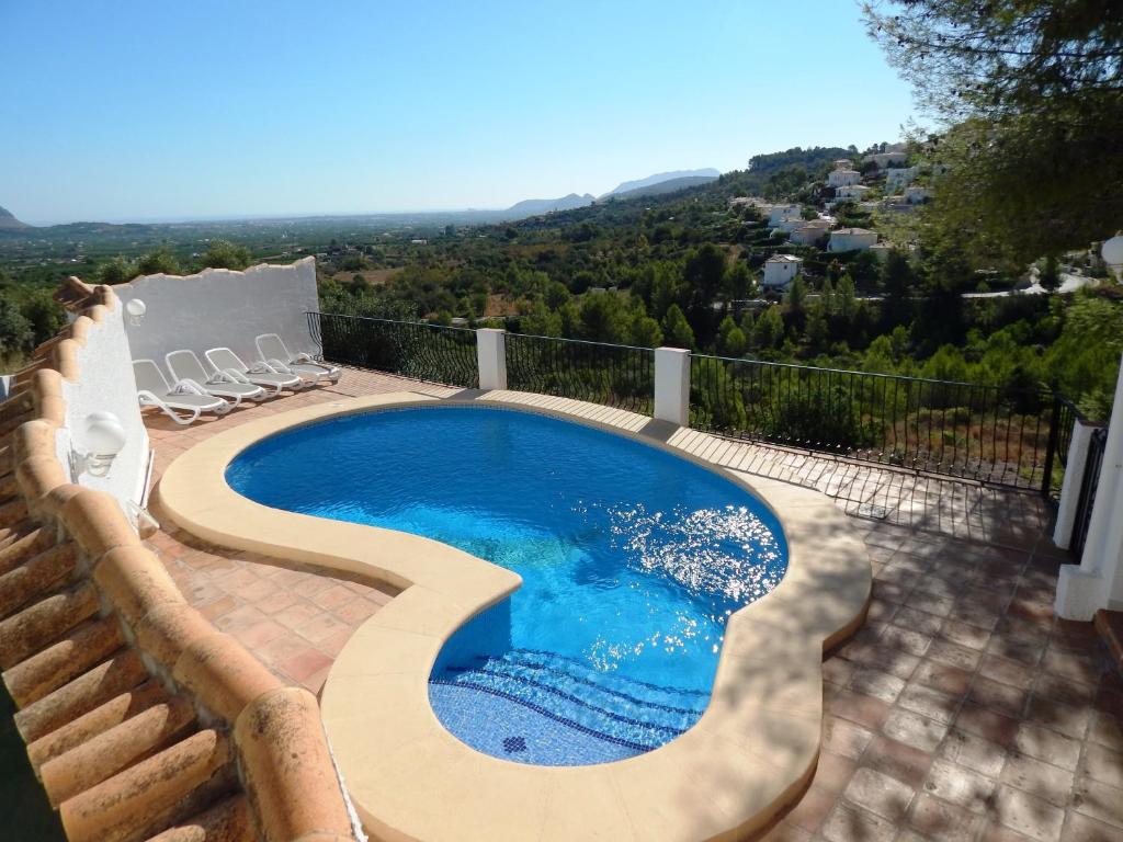 een zwembad op een patio met stoelen eromheen bij Villa Paloma in Orba