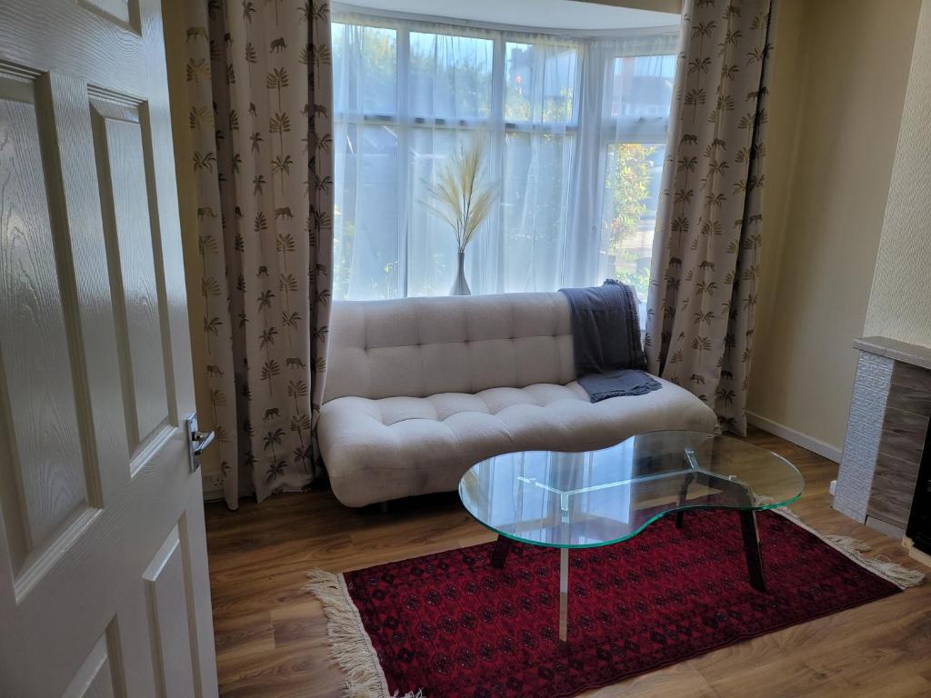 - un salon avec un canapé et une table en verre dans l'établissement Bright And Homely 1 bedroom flat, à Reading