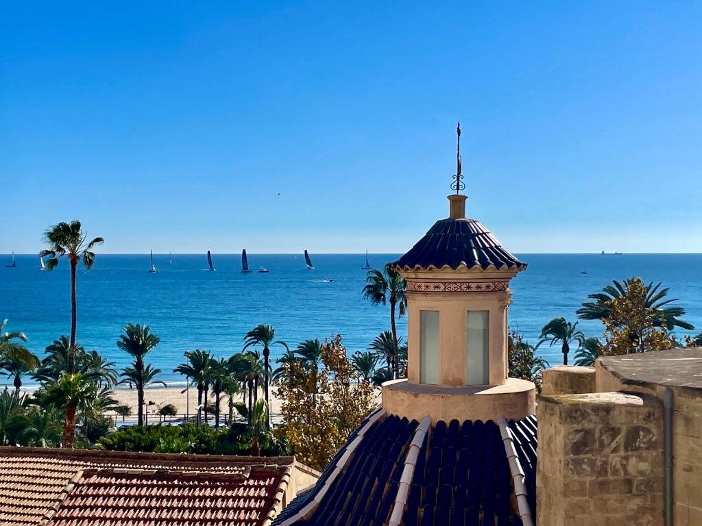 a tower on top of a building next to the beach at VillaVieja17 Studio-Apartments in Alicante