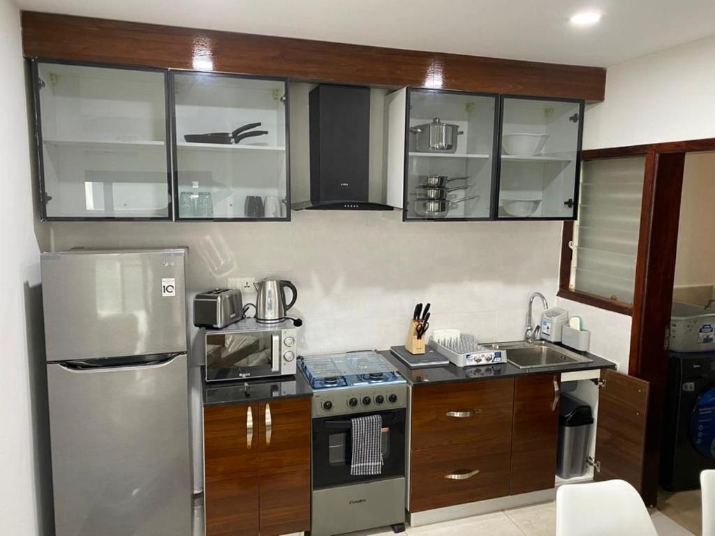 una cocina con electrodomésticos de acero inoxidable y armarios de madera en Benteh Aqua View, en Banjul