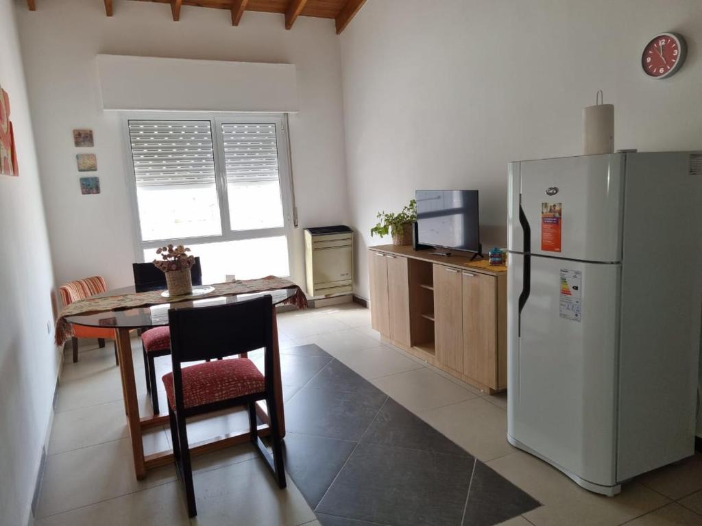 een keuken met een tafel en een koelkast bij Departamento Las Calandrias in Cipolletti