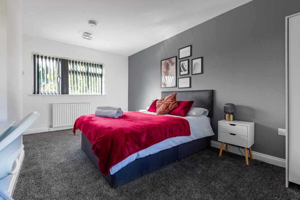 een slaapkamer met een bed met een rode deken bij Tranquil Six Bedroom Haven in Northampton