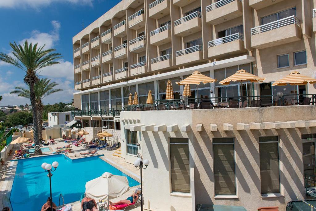 a hotel room with a large pool and a balcony at Agapinor Hotel in Paphos