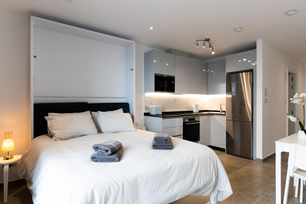 een slaapkamer met een groot wit bed en handdoeken bij E1 Rock View Studio10 -Hosted by Sweetstay in Gibraltar
