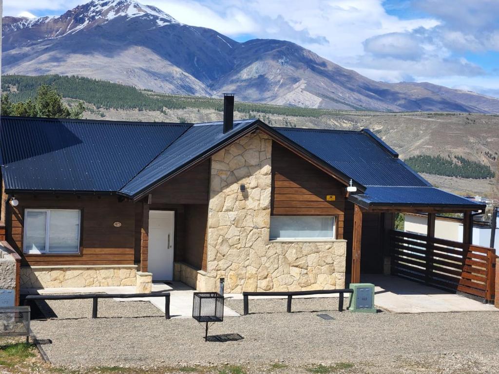 a cabin with a blue roof with mountains in the background at Los Reales in Esquel