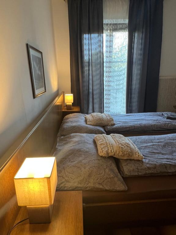 - 2 lits dans une chambre avec une lampe et une fenêtre dans l'établissement Mediterrane Ferien Villa am Neusiedler See, à Gols
