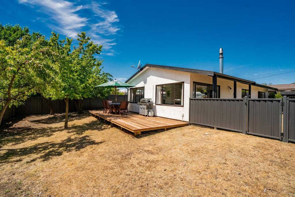 a house with a fence and a wooden deck at Wander into Wanaka in Wanaka