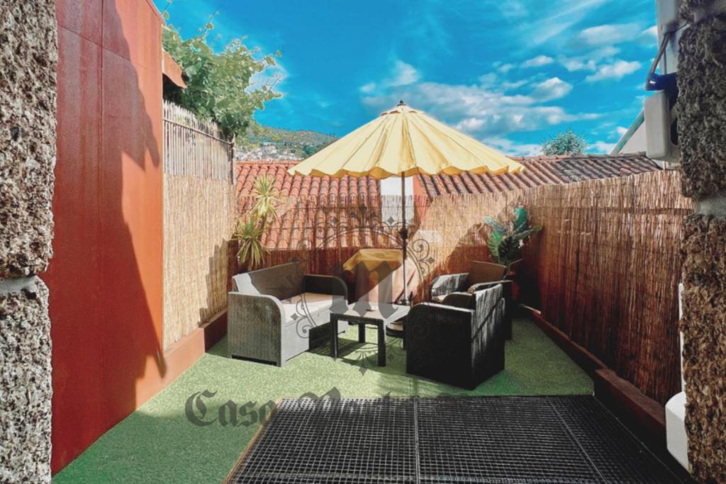 a patio with two chairs and an umbrella at Casa Porta Nova AL in Guimarães