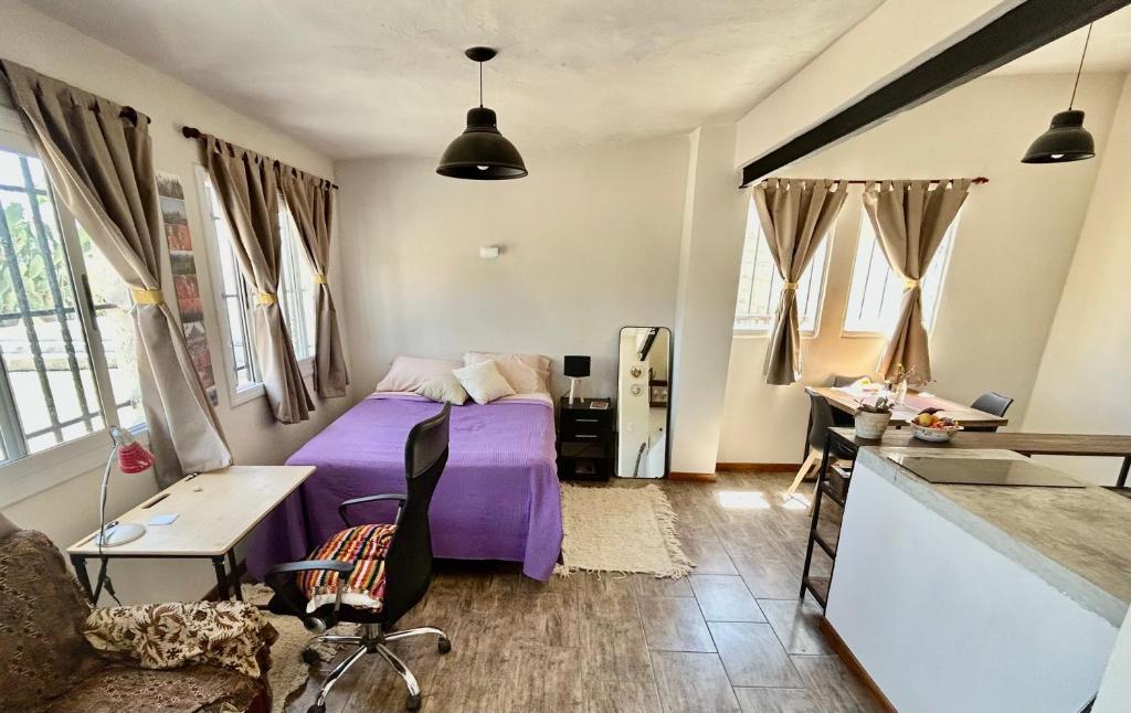 um quarto com uma cama roxa num quarto em El Satélite em Córdova