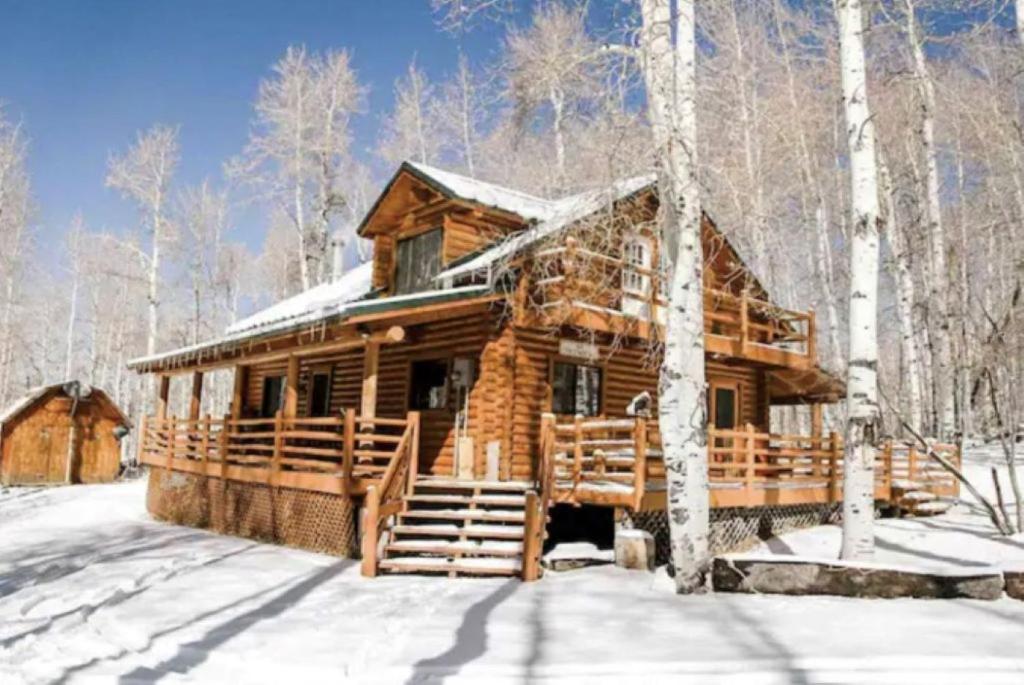 una cabaña de madera en el bosque en la nieve en Peaceful Log Cabin in the Woods. 20 miles from ski resorts. Family Friendly!, en Heber City