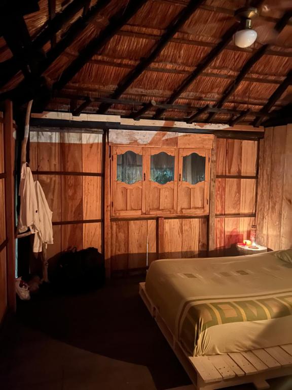 um quarto com uma cama e paredes de madeira em Eco-Conscious Oasis Punta Arena 01 em Playa Punta Arena