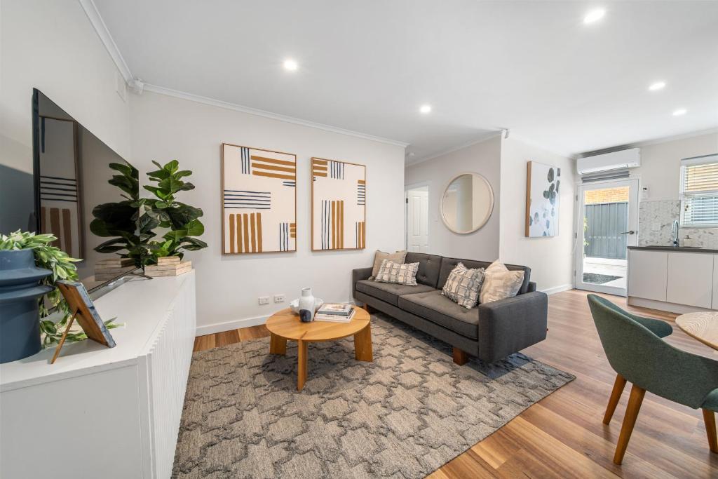 a living room with a couch and a table at One Tea House - Contemporary Cityside Comfort in Keswick