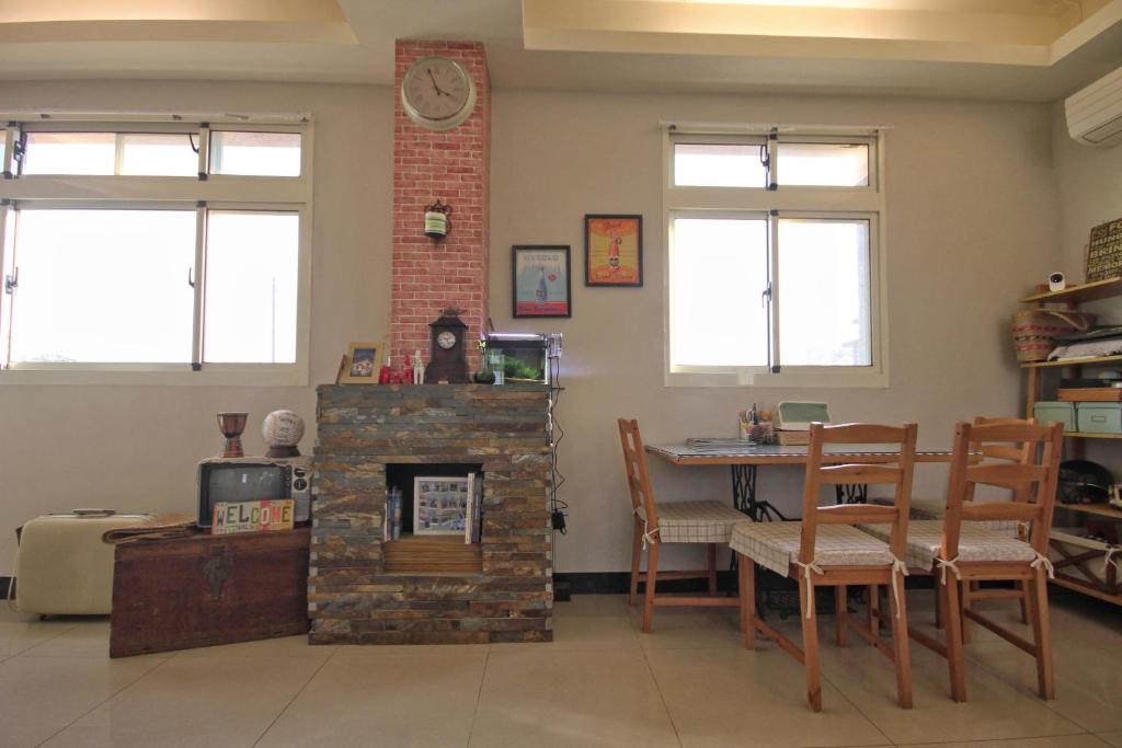 a living room with a brick fireplace and a table at Happy Tree Hostel in Jinning