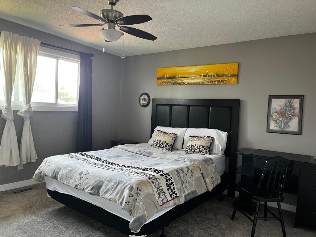 een slaapkamer met een bed en een plafondventilator bij hunter' s new home! in Calgary