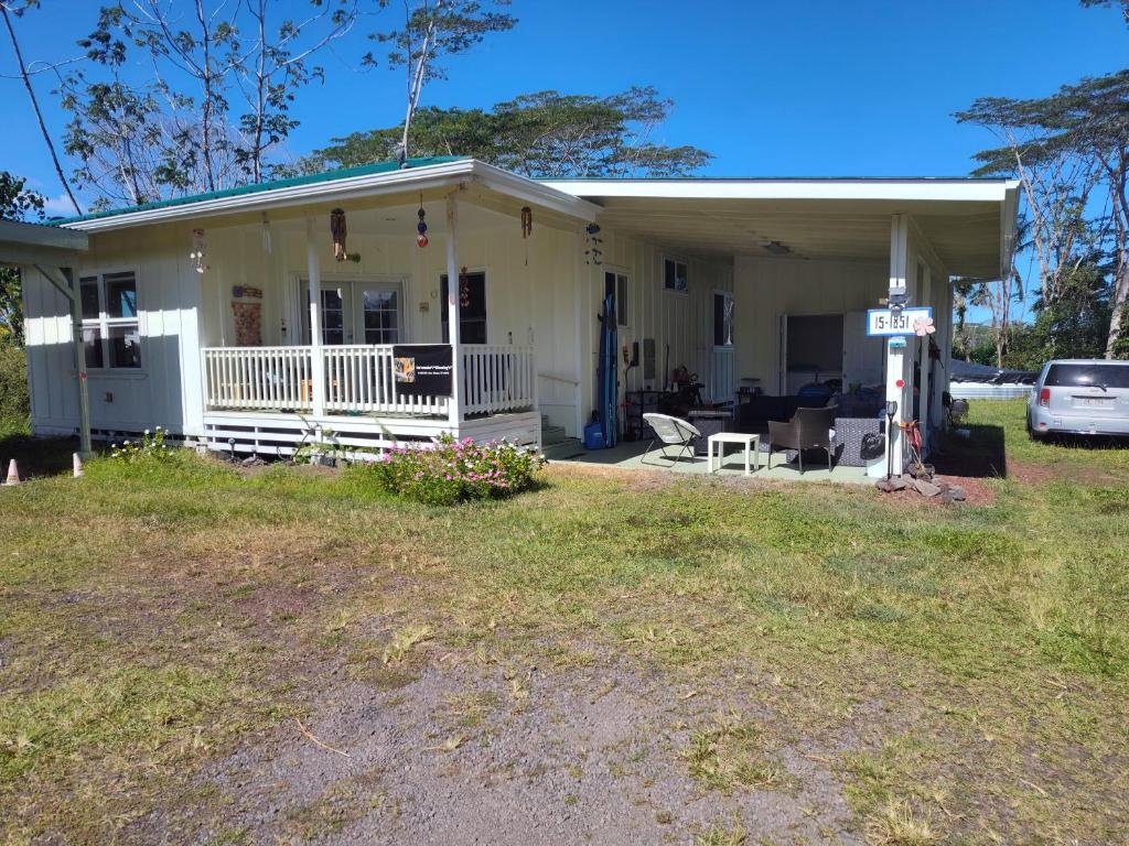 una pequeña casa blanca con una gasolinera en Hoomaikai Blessings, en Keaau