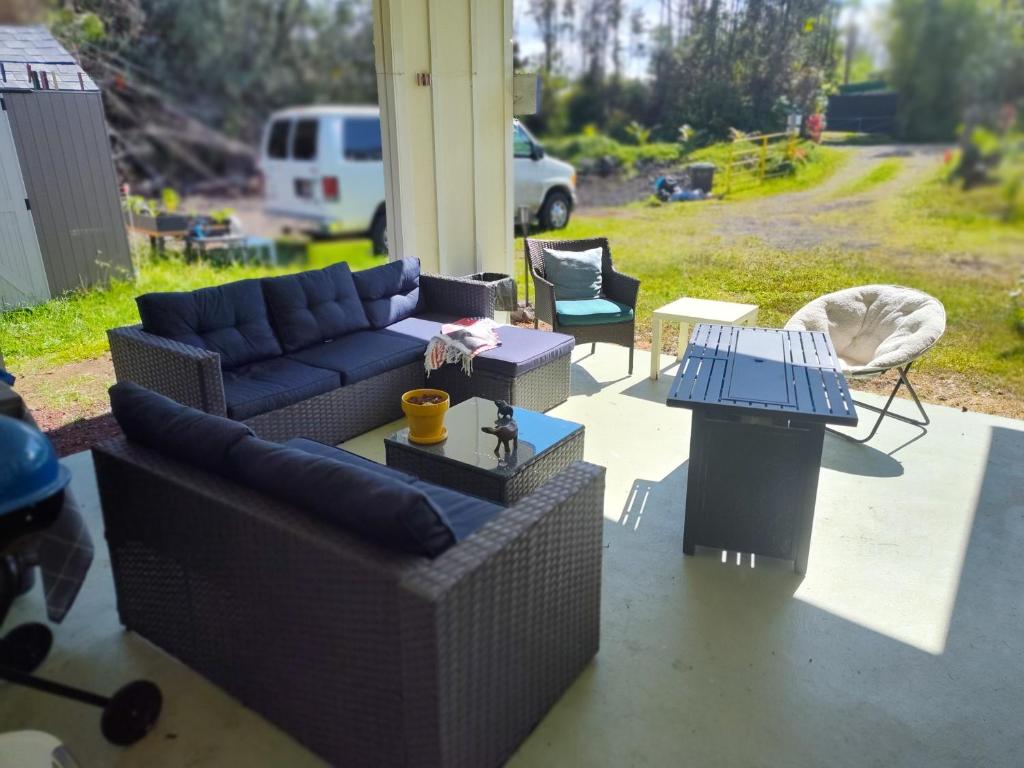 a living room with couches and tables on a patio at Hoomaikai Blessings in Keaau