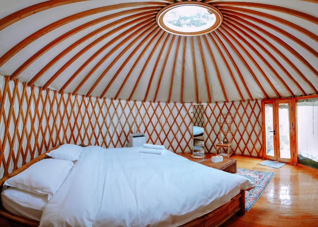 1 dormitorio con 1 cama grande en una yurta en Nomad Yurts, en Corón