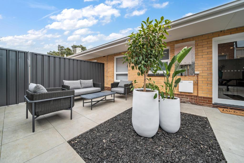 a patio with two large white pots with plants at Two Tea House - Contemporary Courtyard Comfort in Keswick
