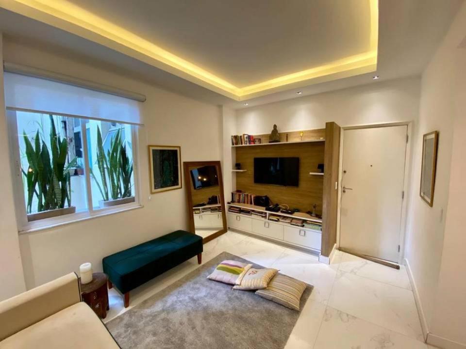uma sala de estar com um sofá e uma televisão em Cozy and Deluxe Apartment at the Heart of Ipanema no Rio de Janeiro