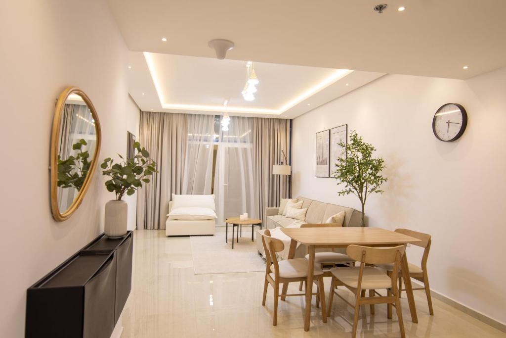 ein Wohnzimmer mit einem Tisch und einem Sofa in der Unterkunft Luxury Brand New 1BD Apt in AJMAN FREE Parking NEAR Beach in Ajman 