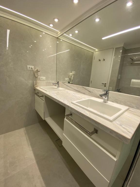 a bathroom with a sink and a mirror at Ninety Suíte Premium in Sao Paulo