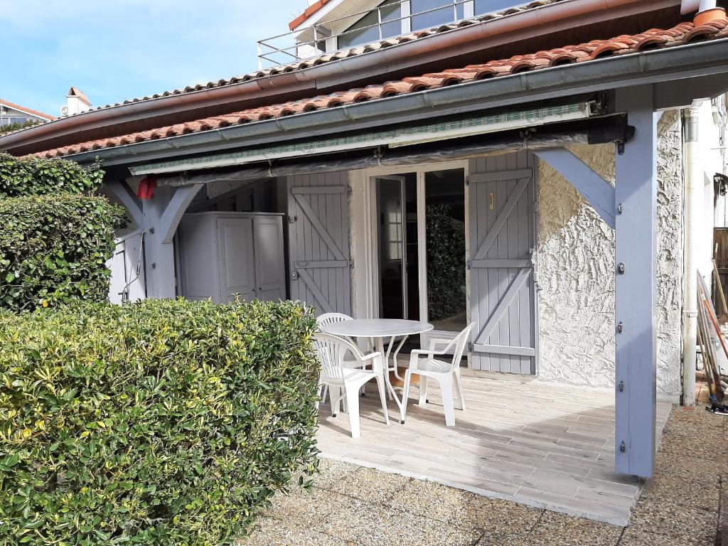 a patio with a table and chairs on it at Villa Patio Charmante, 2 Pas des Plages, Terrasse, Parking, Piste Cyclable - FR-1-239-892 in Capbreton