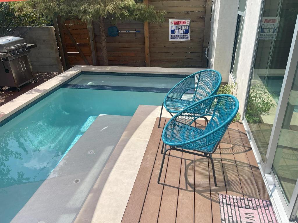 Duas cadeiras sentadas num deque ao lado de uma piscina em Stunning Modern Home w Pool & Hot Tub in DT Austin em Austin