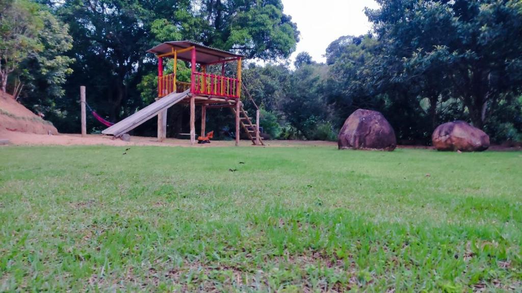 un parque infantil con un tobogán en un campo de césped en Cantinho vovó Nita, en Marechal Floriano