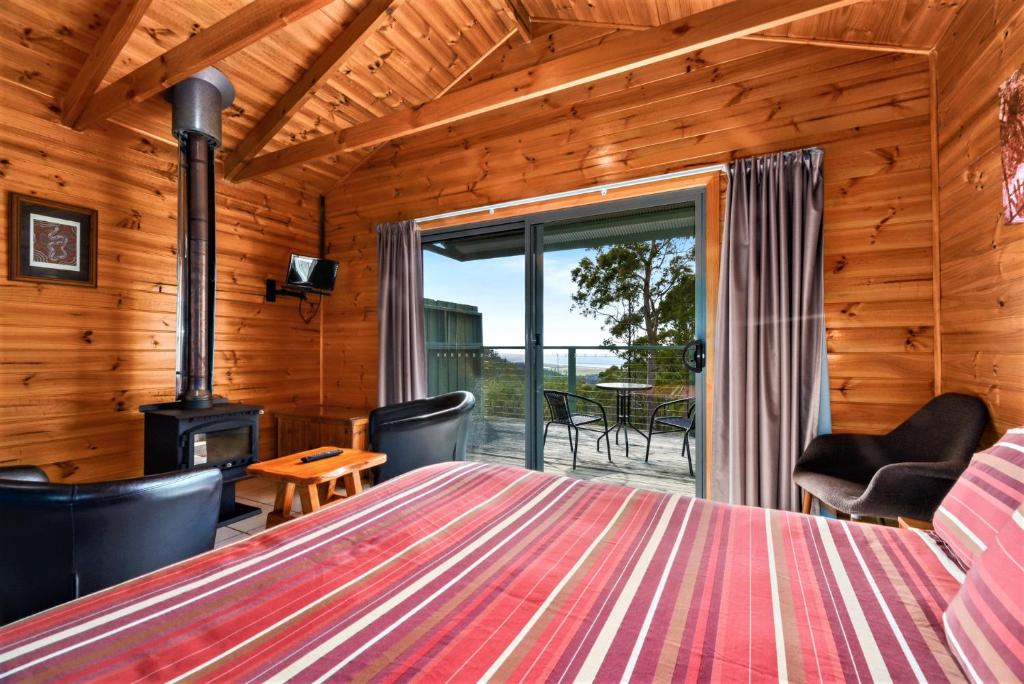 Zimmer mit einem Bett, einem Kamin und einer Terrasse in der Unterkunft Lumera Eco Chalets in Saint Marys