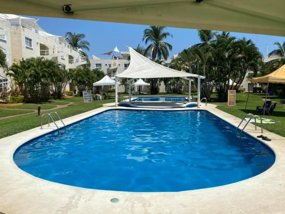 une grande piscine d'eau bleue dans l'établissement Casa Puko, à Acapulco