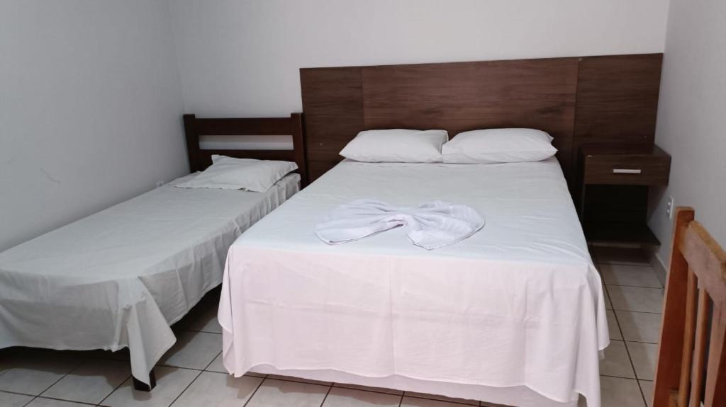 - 2 lits avec des serviettes blanches assises au-dessus dans l'établissement Hotel Turazzi, à Cáceres