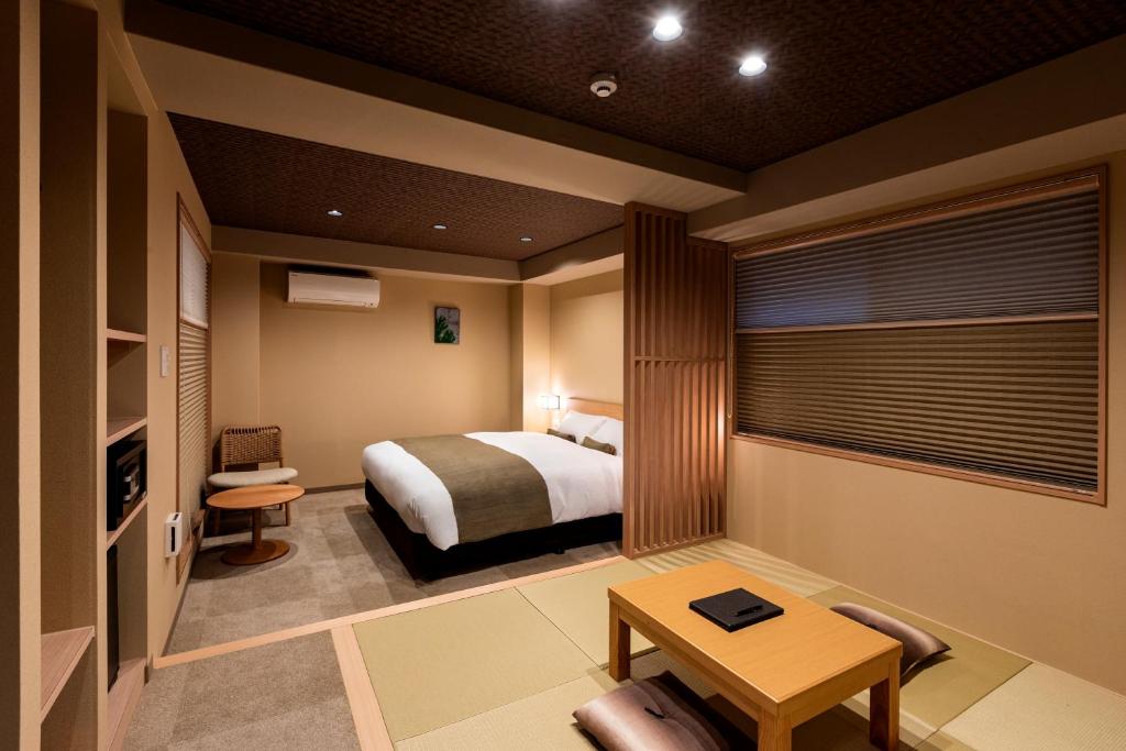 京都市にあるRinn Kitagomon （鈴 北御門）のベッドとテーブルが備わるホテルルームです。