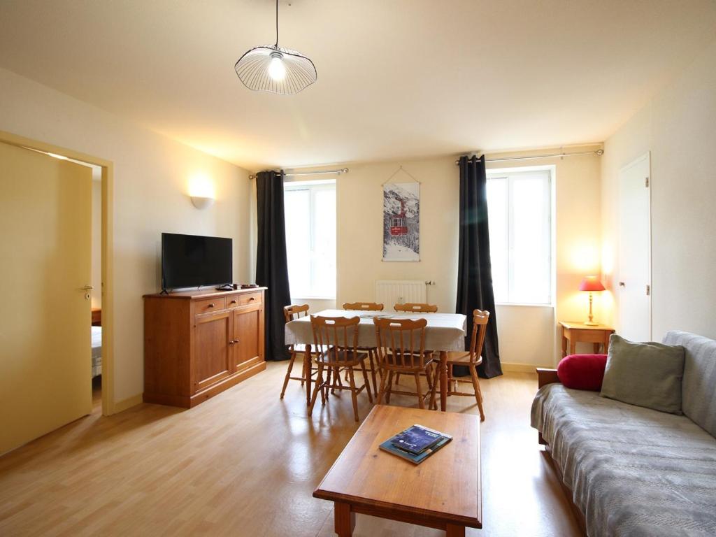 un salon avec un canapé, une table et des chaises dans l'établissement Appartement T2 à La Bourboule avec WiFi, parking, animaux acceptés - FR-1-608-254, à La Bourboule
