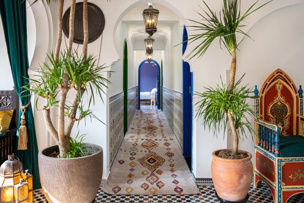 a hallway with potted plants and a blue door at The Arabian Nights B&B in Chongqing