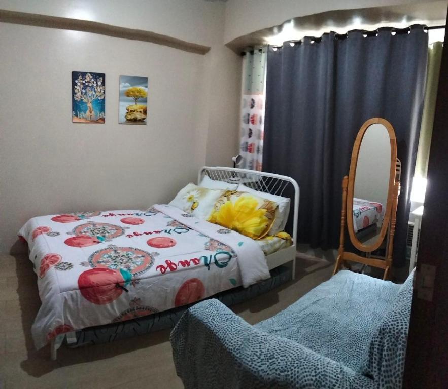 een kleine slaapkamer met een bed en een spiegel bij Sheila’s Condotel at One Palm Tree in Manilla