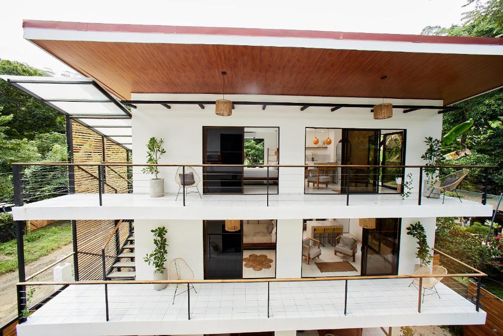 a large white house with a large balcony at Encantador Loft con Piscina 1 BDR in Santa Teresa Beach