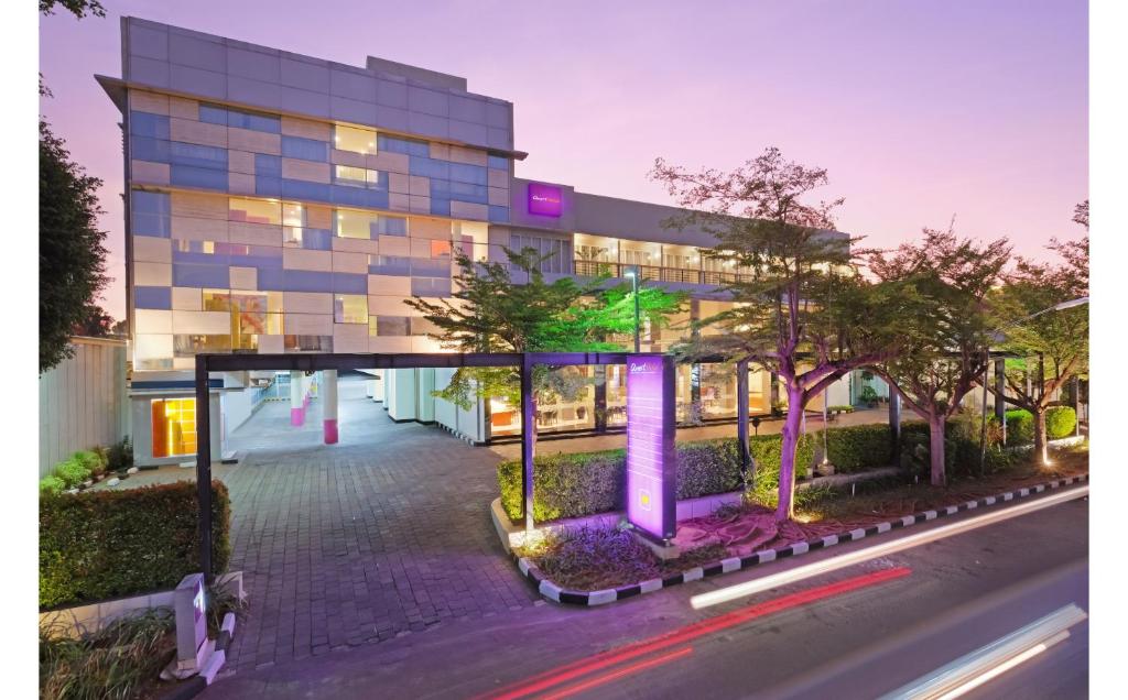 un edificio con luces púrpuras frente a una calle en Quest Hotel Simpang Lima - Semarang by ASTON en Semarang